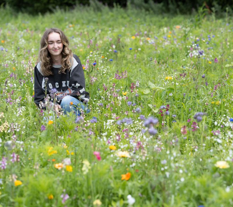 A woman in a field of wildflowers.