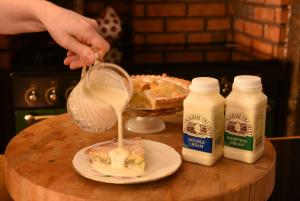 Ballyrashane cream being poured onto a slice of apple pie
