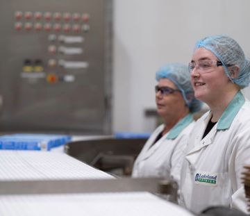 Two members of the Lakeland Dairies team smiling while at work.