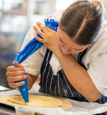 Chef piping Millac Gold Double mixture onto a tray, using a piping bag