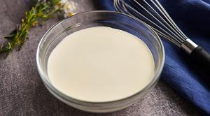 A bowl of Lakeland Dairies cream, with a whisk placed next to it