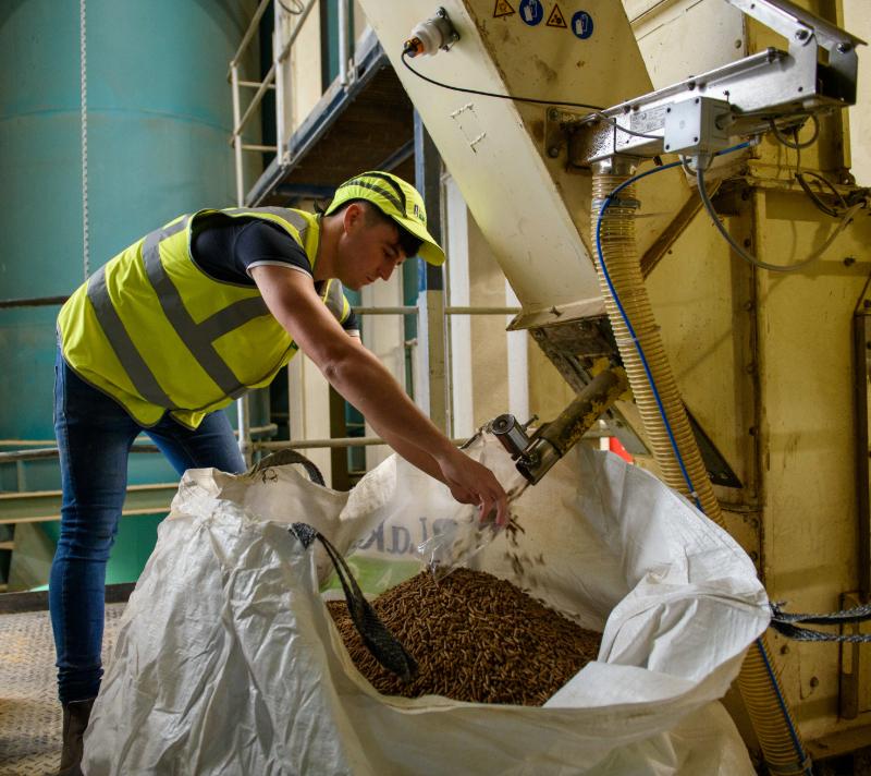A Lakeland Agri team member filling a tonne bag with meal.