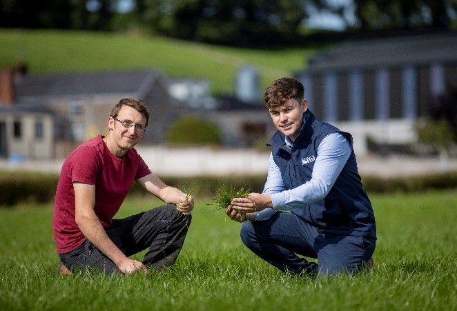 A Lakeland Dairies team member and a Lakeland Dairies milk supplier checking the grass.