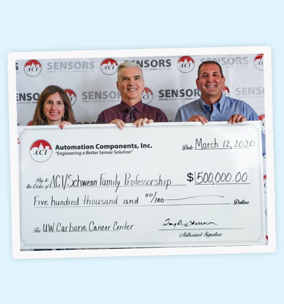 3 people holding a check