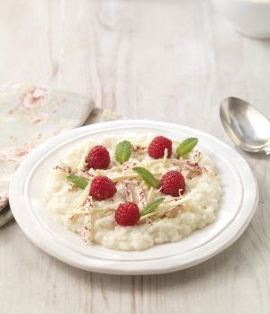 Recipe serving suggestion of white chocolate rice pudding made with Lakeland Dairies skimmed milk powder, topped with fresh raspberries