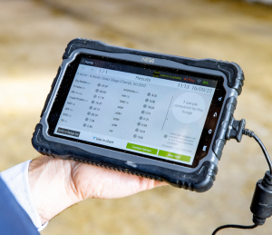 Grass quality results displayed on a screen in hand.